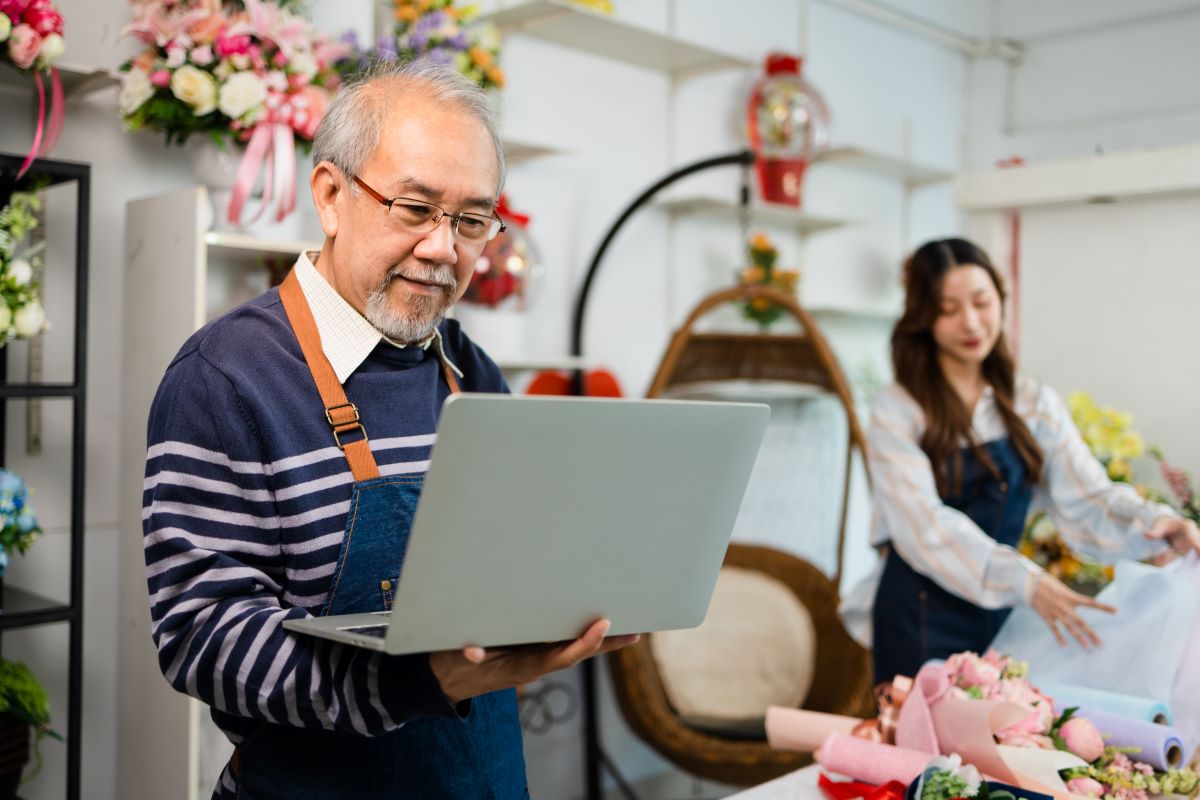 Senior business owner reviewing something on his laptop