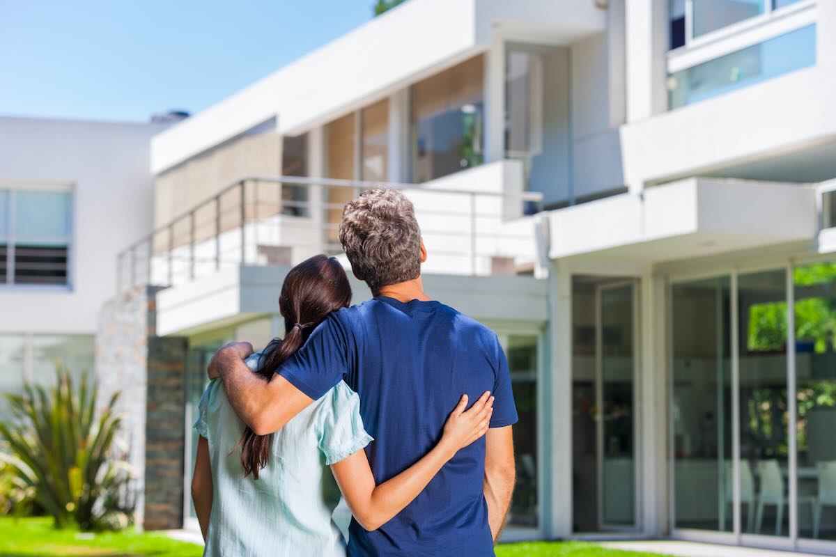 Couple looking at their house, shot from the back