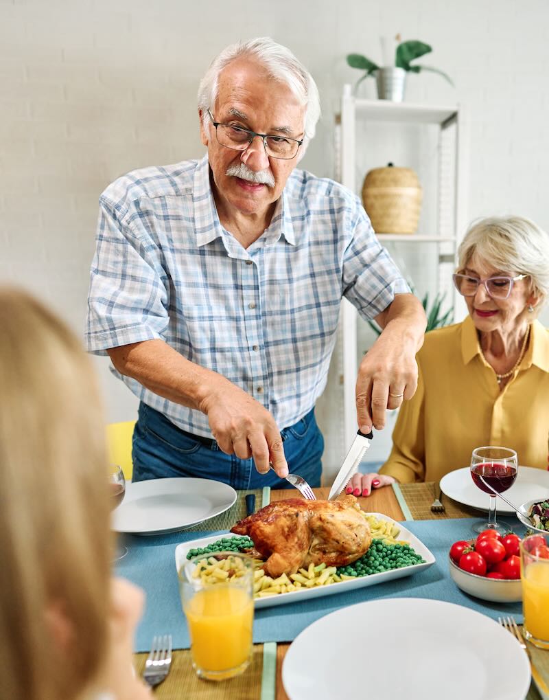 Happy multi-generation family gathering around dining table